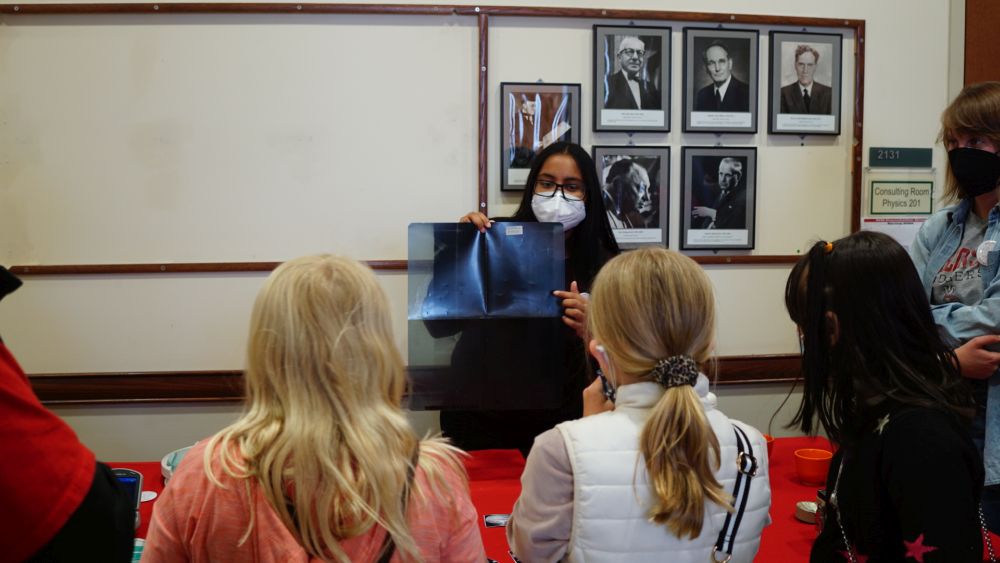 student showing xray sample at a physics fair with middle schoolers