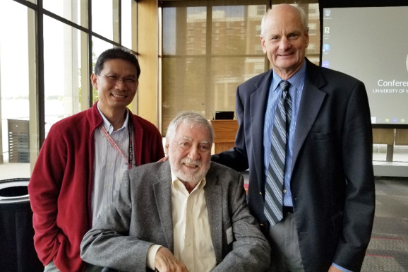 Guang-Hong Chen, Chuck Mistretta and Tom Grist stand together in a room filled with windows