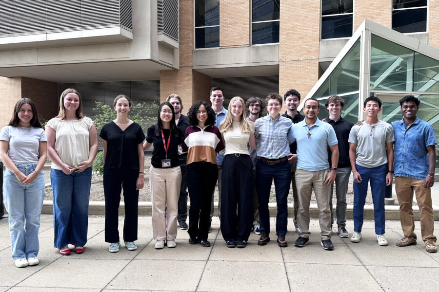 group of students stand outside on a patio