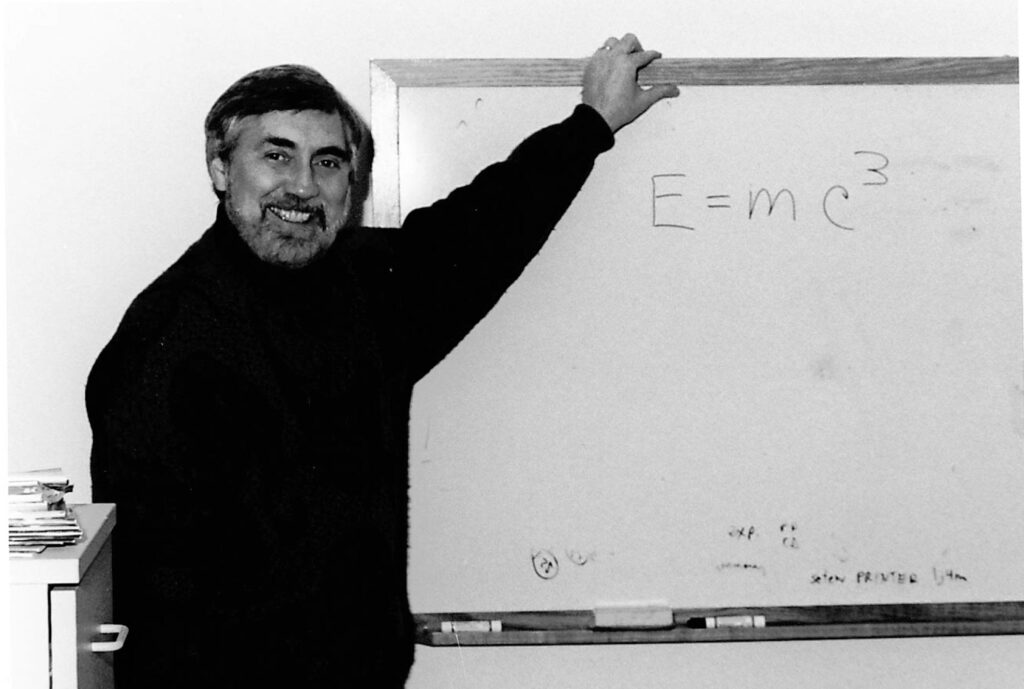 Chuck Mistretta stands in front of a white board