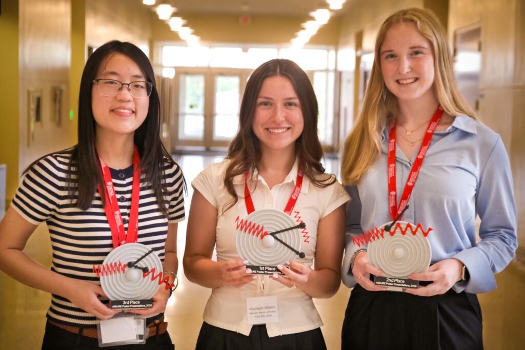 Three poster presentation winners hold their awards